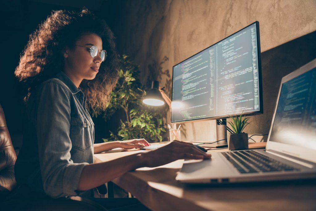 Women at a desk coding on a computer. 